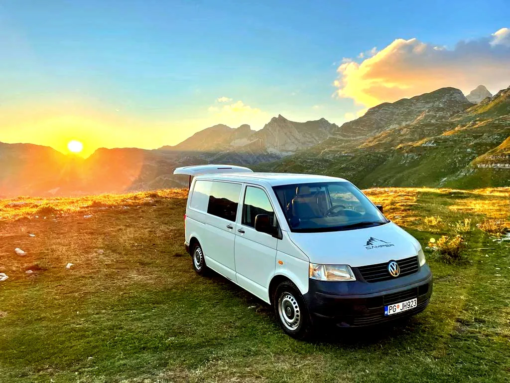 VW T5 White camper in the mountains at sunrise